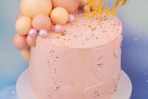 Tårta till en babyshower med vanilj-hallon smak, dekoration av chokladsfärer och italiensk smörkräm.
