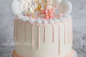 Babyshower-tårta, dekorerad med drip, maränger och en söt liten dansande björn av choklad.