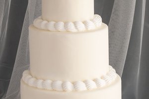 En sparsamt dekorerad bröllopstårta med tre våningar.